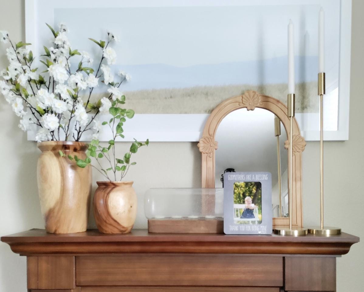 a wooden dresser topped with vases filled with flowers