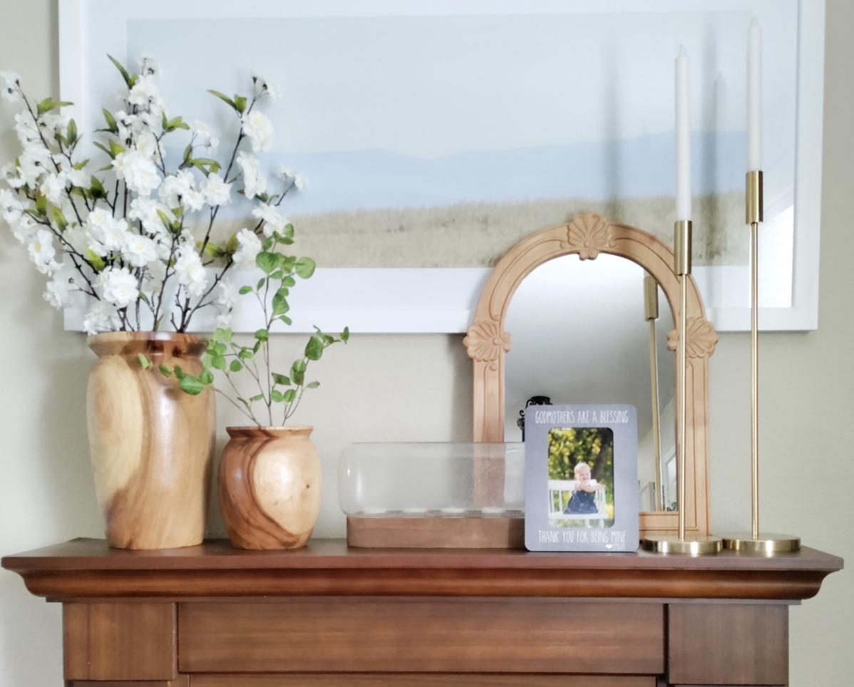 a wooden dresser topped with vases filled with flowers